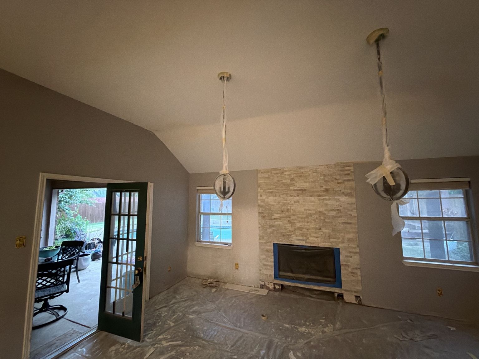 Wide view of the fireplace centered between windows and the surrounding room