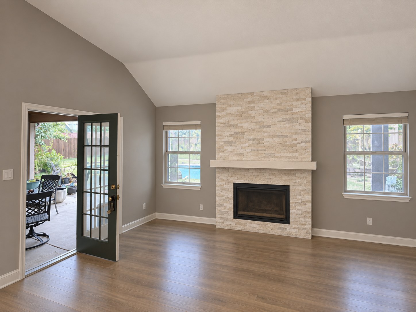 Stone fireplace between two windows beside the patio door